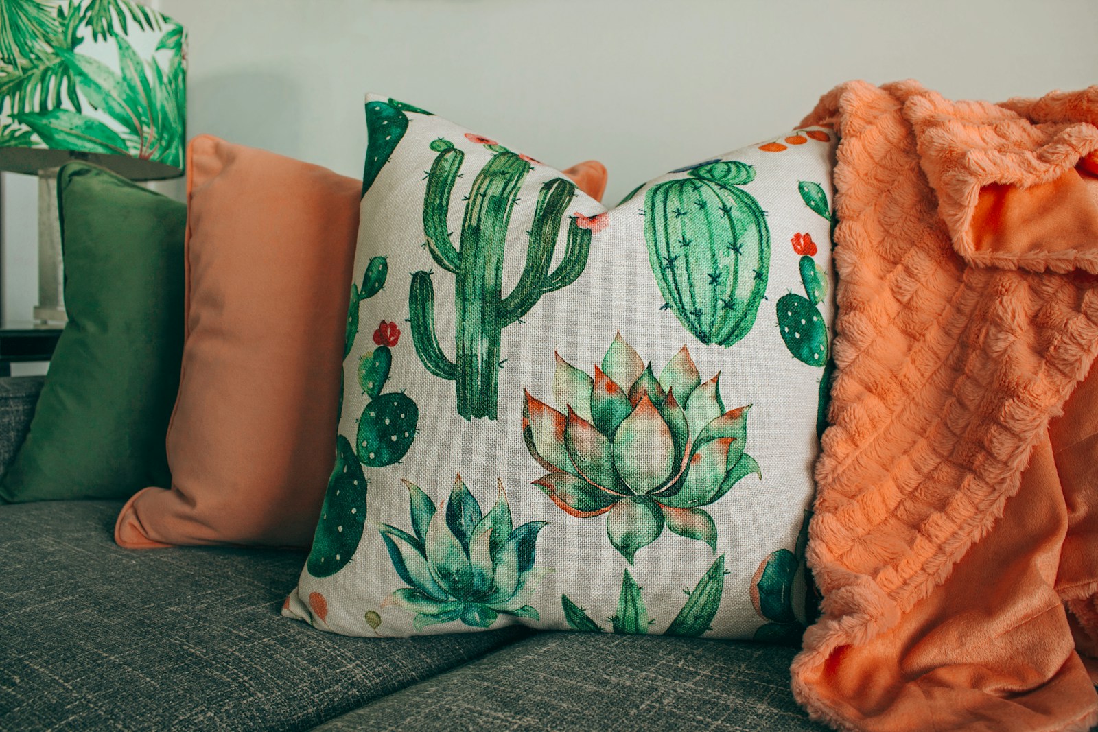 three green, orange, and white throw pillows on sofa